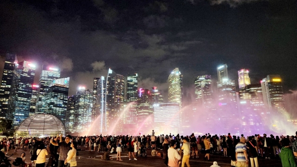 작년 12월 10일 싱가포르 마리나베이 샌즈 리조트 앞에서 관광객들이 화려한 야간 분수쇼를 지켜보고 있다.