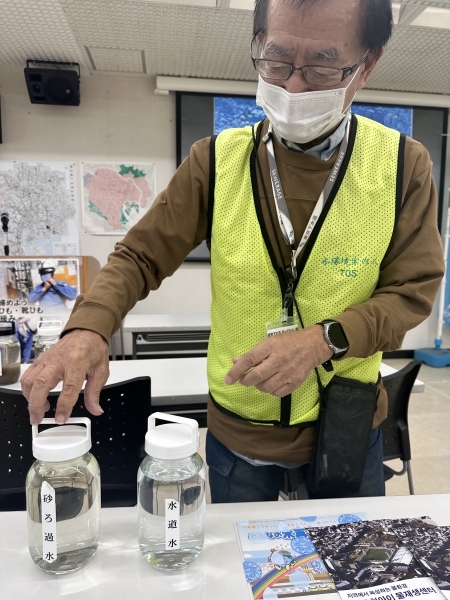 오치아이 물재생센터 직원이 하수 샘플을 통해 물 정화 과정을 설명하고 있다.