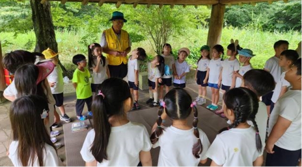 시니어 제주곶자왈 수호대 참여자가 생태체험 강사활동으로 아이들과 만나고 있다.