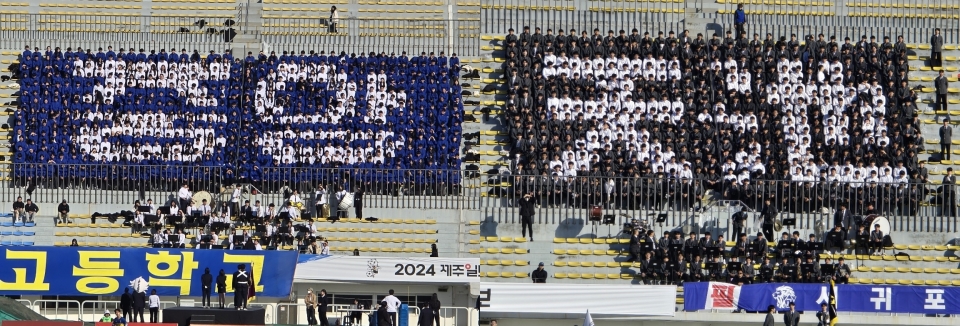 21일 제주종합경기장 주경기장에서 펼쳐진 고등부 예선전 경기에서 응원을 펼치고 있는 서귀포고등학교(사진 오른쪽)과 제주중앙고등학교(사진 왼쪽)